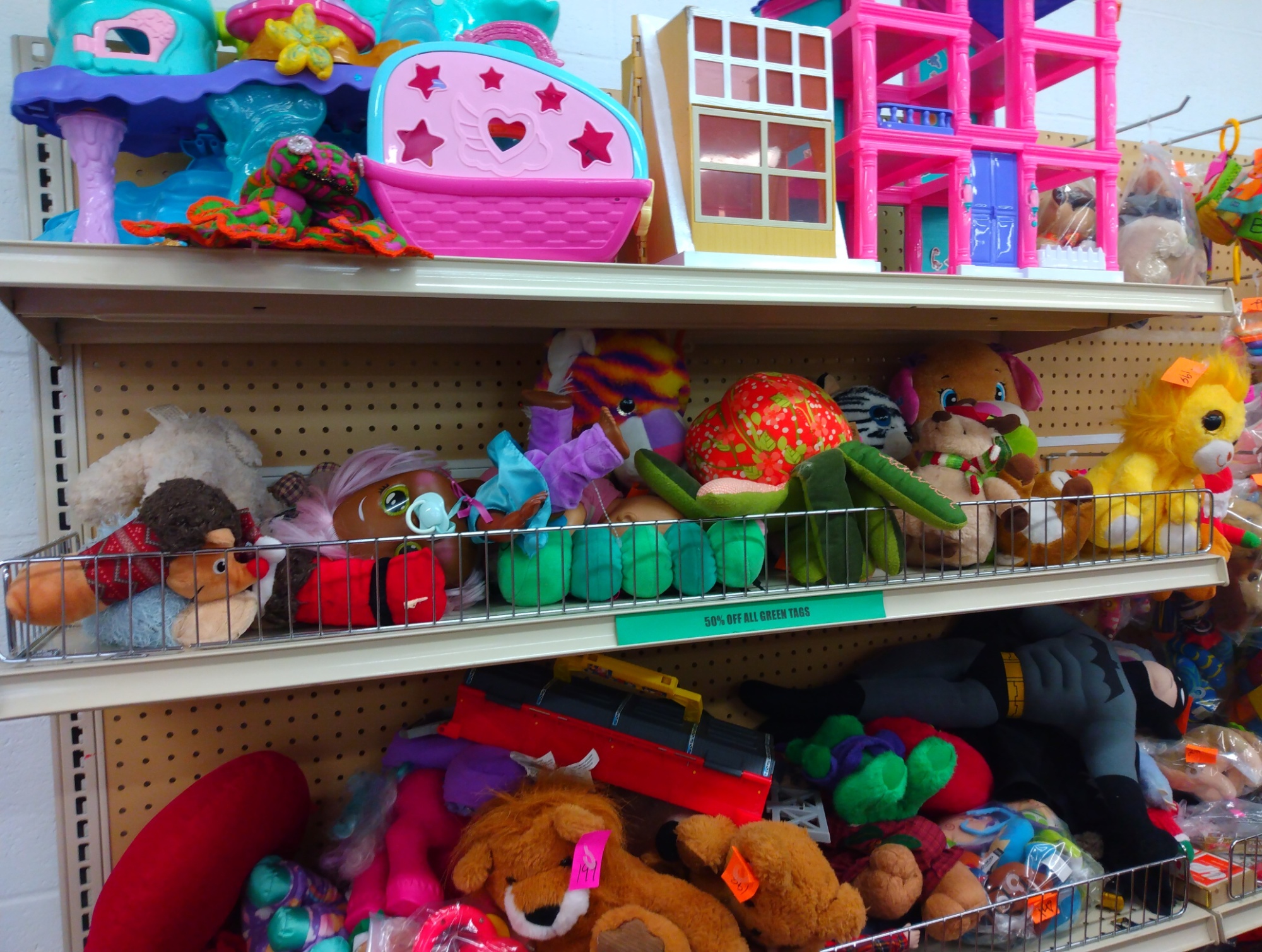 An image of toys on three store shelves at a thrift store